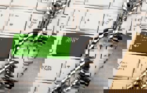 In the background is a keyboard with the return key replaced by a 'Security' key. In front is a padlock and chain.