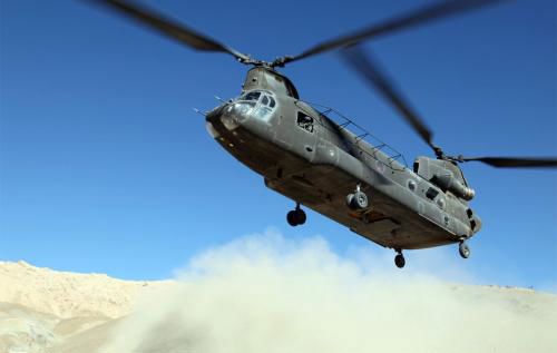 A Chinook helicopter taking off in the desert.
